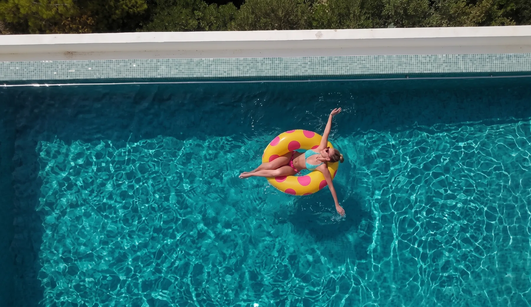 Mulher flutuando em piscina de água cristalina